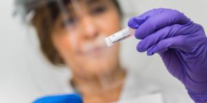 person in lab holding up sample