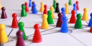 Colorful human silhouette-like figurines gathered together on a matrix